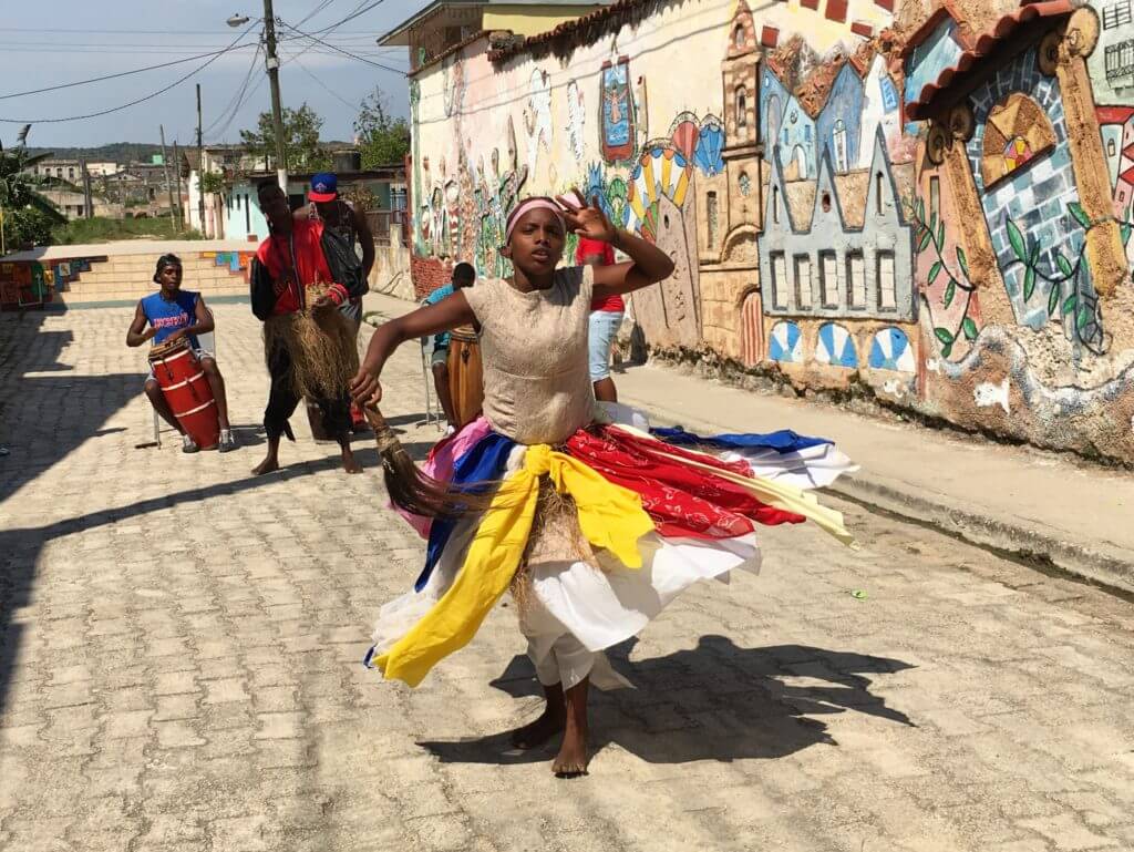 A girl dressed in traditional garments dancing in Callejon de las Tradiciones. Discover picture perfect reasons to visit Cuba. Find out why it's become such a popular travel destination, and what you shouldn't miss when you're there! And for more travel tips and wanderlust inspiration follow The Scenic Suitcase on Pinterest!