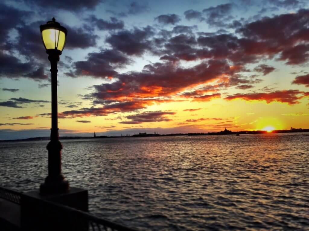 Sunset overlooking the Statue of Liberty and Ellis Island. Discover 30 picture perfect reasons to visit New York City. And for more travel tips and wanderlust inspiration follow The Scenic Suitcase on Pinterest!