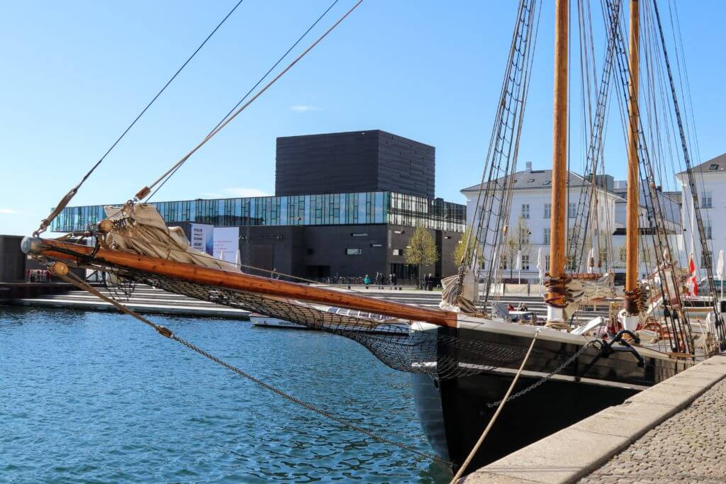 Modern architecture and vintage boats along the waterfront. Discover 12 picture perfect reasons to visit Copenhagen, Denmark. Want even more wanderlust inspiration? Follow The Scenic Suitcase on Pinterest!