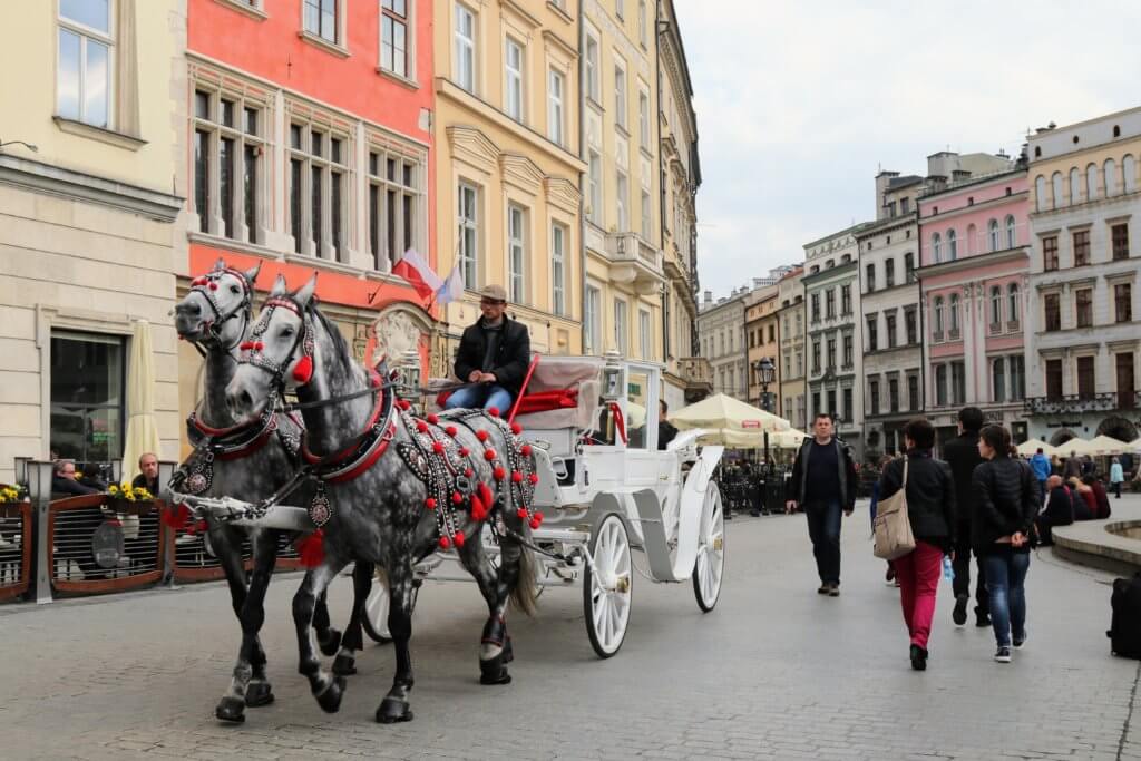 A horse drawn carriage down cobblestone streets. Just one of the many reasons to visit Krakow, Poland. For more travel tips and wanderlust inspiration follow The Scenic Suitcase on Pinterest!