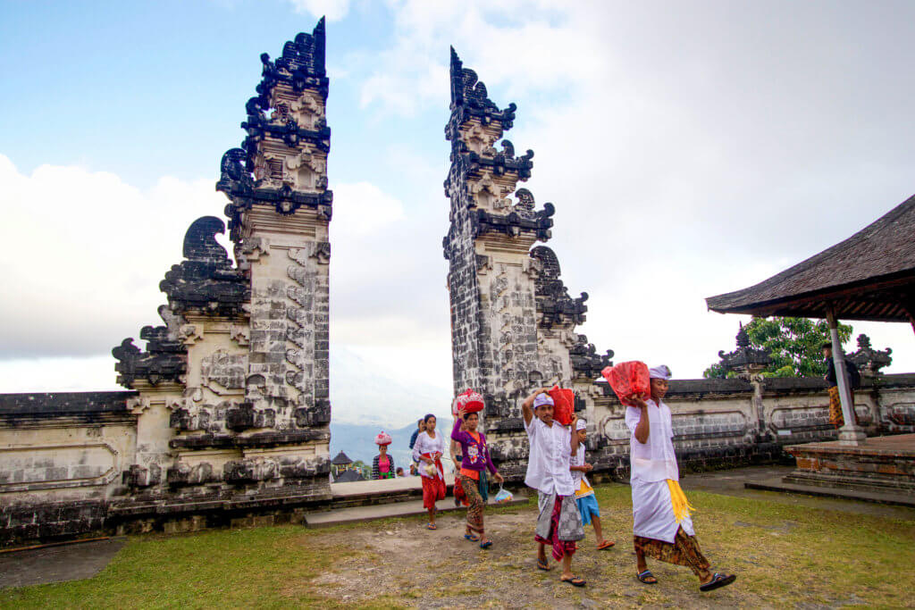 People carrying red packages to the temple through Heaven's Gate in Bali, Indonesia. There are so many benefits to traveling beyond beautiful pictures and a sun-kissed tan. Find out 7 astonishing ways travel changes you for the better like little else in life can. And for more travel tips and wanderlust inspiration follow The Scenic Suitcase on Pinterest!