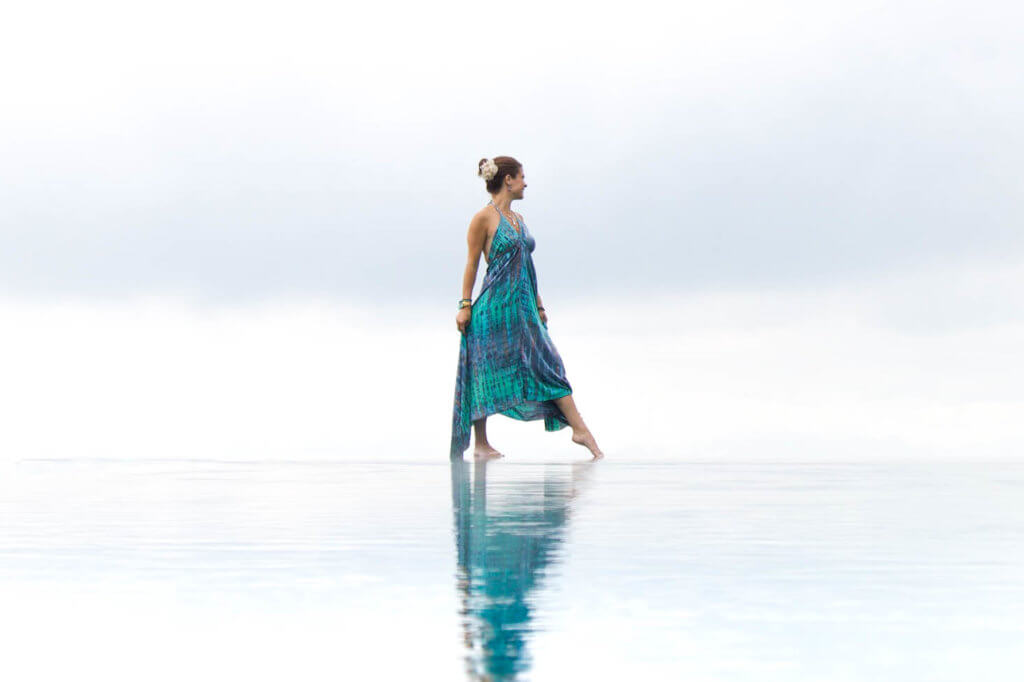 Posing at the edge of an infinity pool in a blue and turquoise dress. There are so many benefits to traveling beyond beautiful pictures and a sun-kissed tan. Find out 7 astonishing ways travel changes you for the better like little else in life can. And for more travel tips and wanderlust inspiration follow The Scenic Suitcase on Pinterest!