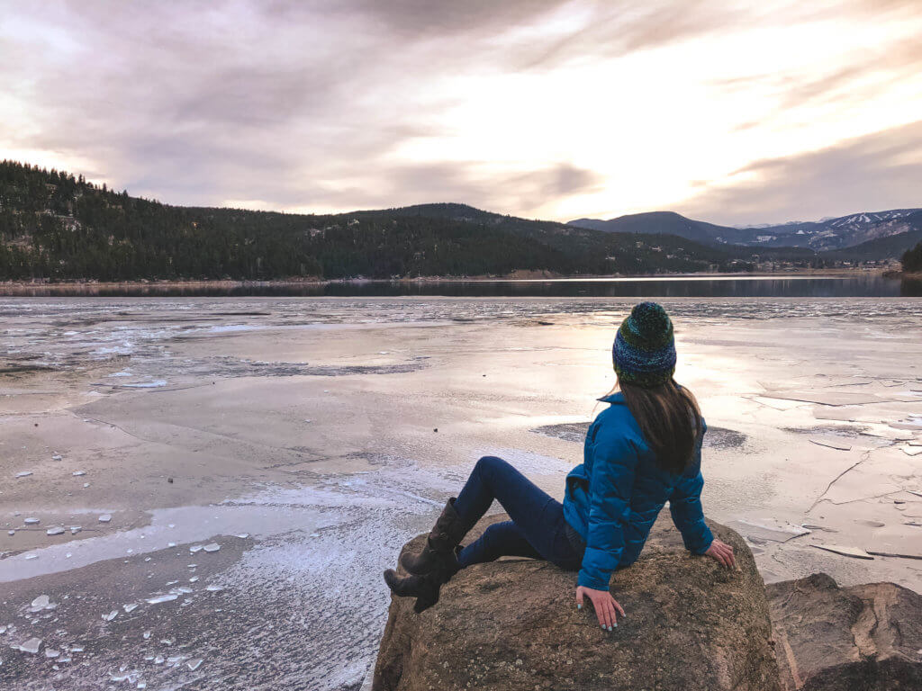 Watching the sunset from a rock along a frozen lake. Discover 20 picture perfect reasons to visit Colorado in winter. And for more travel tips and wanderlust inspiration follow The Scenic Suitcase on Pinterest!
