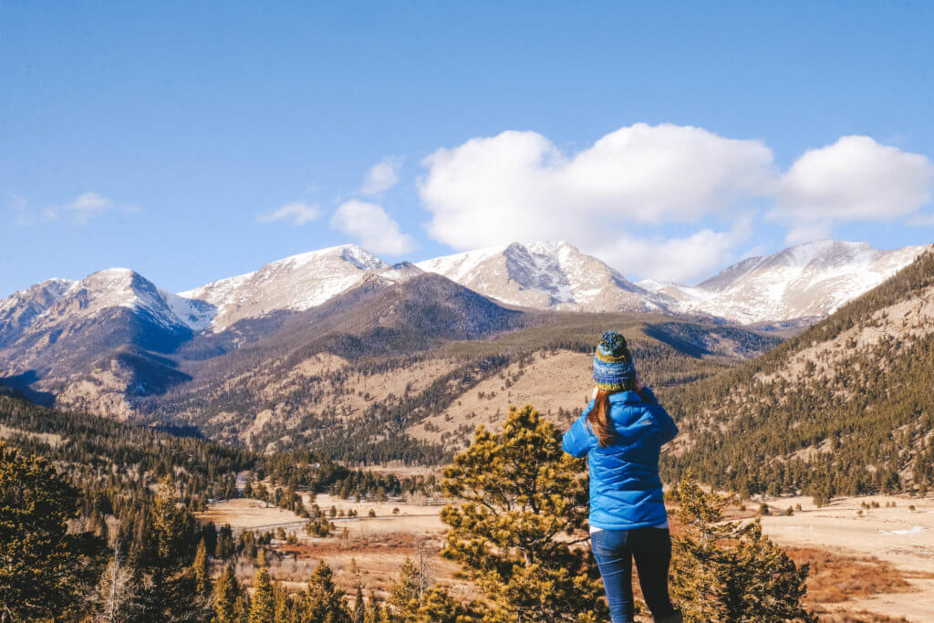 Talking a picture of snowcapped mountains in Estes Park. Discover 20 picture perfect reasons to visit Colorado in winter. And for more travel tips and wanderlust inspiration follow The Scenic Suitcase on Pinterest!