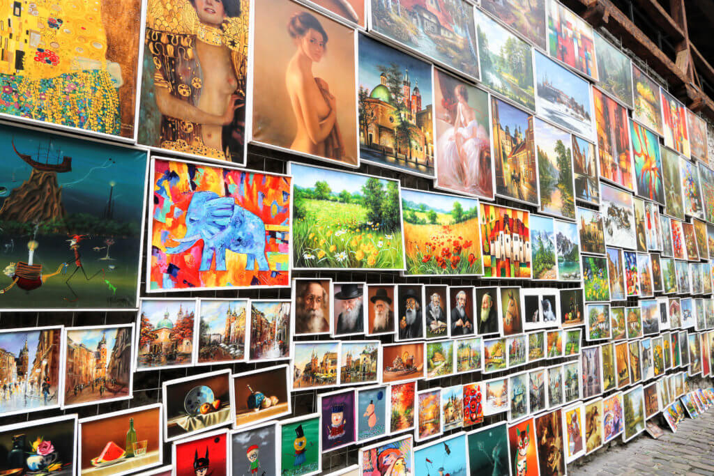 Colorful paintings hung along the outer stone walls of Krakow, Poland's Old Town. Discover the most picture perfect moments of the year. And for more travel tips and wanderlust inspiration, follow The Scenic Suitcase on Pinterest!
