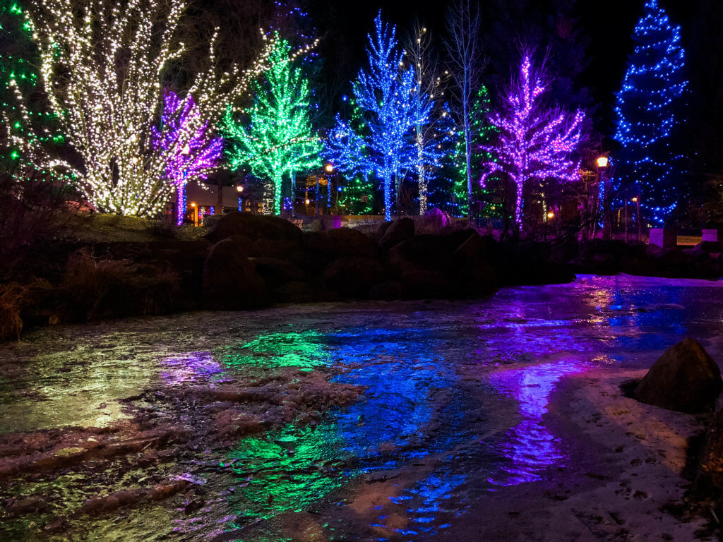 Blue, green, purple, and white Christmas lights along a frozen river. Discover 20 picture perfect reasons to visit Colorado in winter. And for more travel tips and wanderlust inspiration follow The Scenic Suitcase on Pinterest!