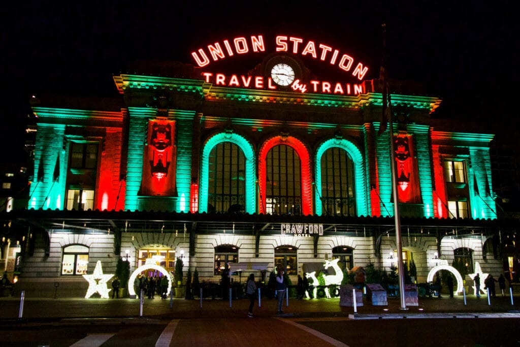 Union Station in Denver lit up with red and green lights for the holiday season. Discover 20 picture perfect reasons to visit Colorado in winter. And for more travel tips and wanderlust inspiration follow The Scenic Suitcase on Pinterest!