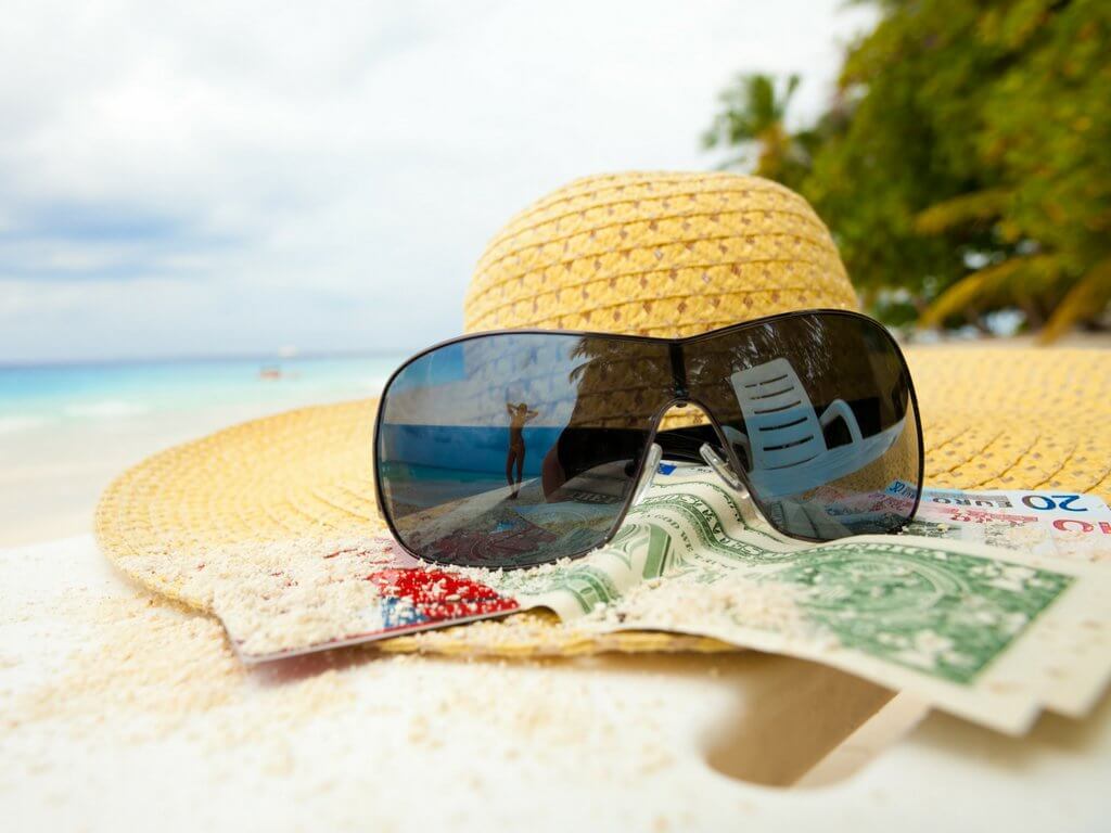A hat, sunglasses, and money sitting on a tropical beach. Discover 6 expert tips on how to save for travel that will help you make your vacation dreams a reality! These proven strategies will allow you to take that trip of a lifetime without taking on debt. For more travel tips and wanderlust inspiration follow The Scenic Suitcase on Pinterest!