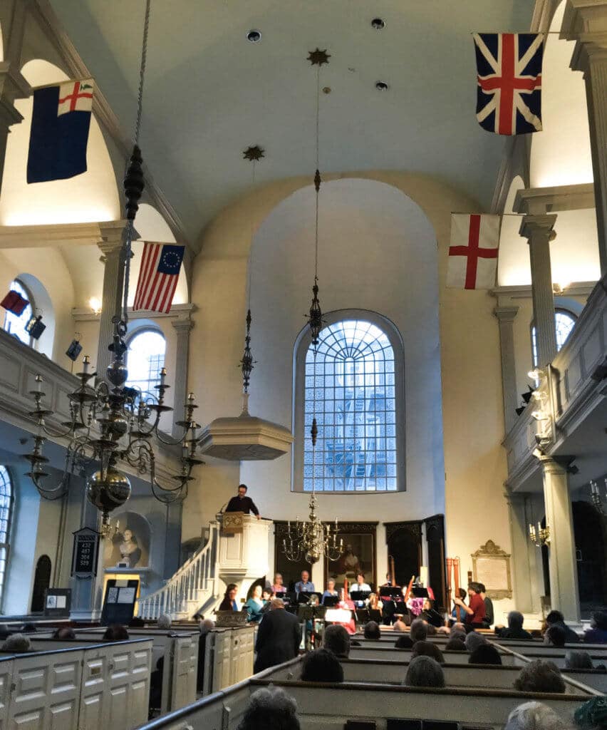The inside of the Old North Church with flags and changeliers hanging from the walls and ceiling. Discover the picture perfect reasons to visit Boston, Massachusetts. From historic landmarks to local favorites, this is what you shouldn't miss on your trip to Beantown. And for more wanderlust inspiration and travel tips follow The Scenic Suitcase on Pinterest!