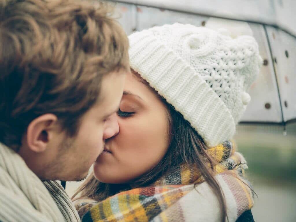 Couple kissing under an umbrella in the rain. Discover 7 essential tips on how to travel as a couple without killing each other. These simple steps will ensure your dream vacation doesn't become a nightmare. And for more wanderlust inspiration and travel tips follow The Scenic Suitcase on Pinterest!