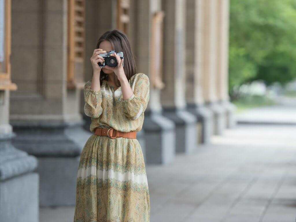 Girl taking a photo in a yellow dress. Discover 7 essential tips on how to travel as a couple without killing each other. These simple steps will ensure your dream vacation doesn't become a nightmare. And for more wanderlust inspiration and travel tips follow The Scenic Suitcase on Pinterest!