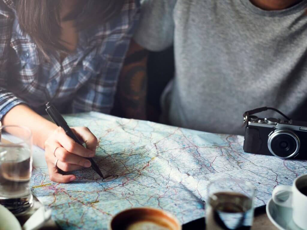 Couple planning a vacation with a map and camera. Discover 7 essential tips on how to travel as a couple without killing each other. These simple steps will ensure your dream vacation doesn't become a nightmare. And for more wanderlust inspiration and travel tips follow The Scenic Suitcase on Pinterest!