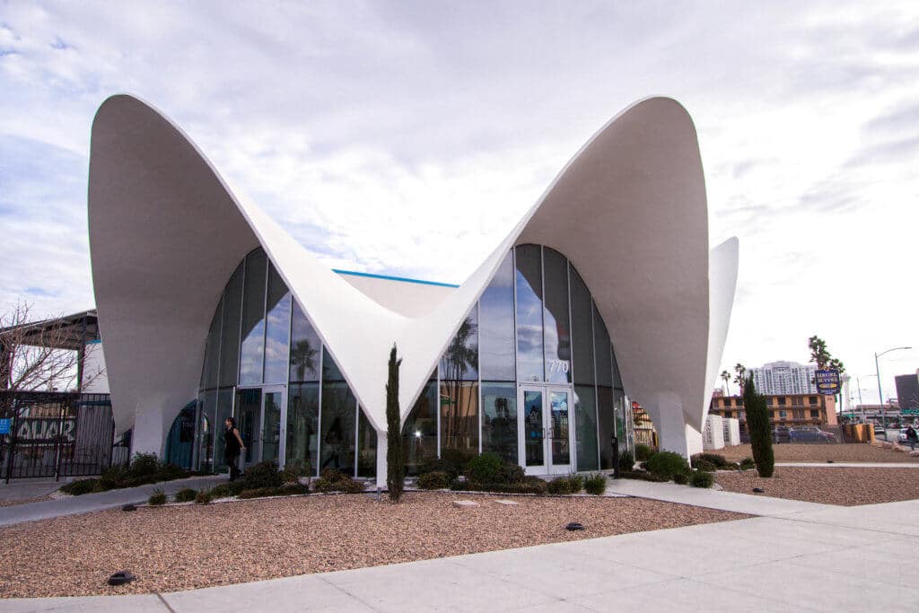 The unique white facade of the Neon Museum building. Visiting the Neon Boneyard is a must when you're in Las Vegas. Discover the rich history behind these Sin City icons, and what you need to know before you go! And for more travel tips and wanderlust inspiration, follow The Scenic Suitcase on Pinterest!