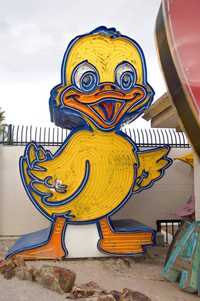 Large yellow neon duck. Visiting the Neon Boneyard is a must when you're in Las Vegas. Discover the rich history behind these Sin City icons, and what you need to know before you go! And for more travel tips and wanderlust inspiration, follow The Scenic Suitcase on Pinterest!
