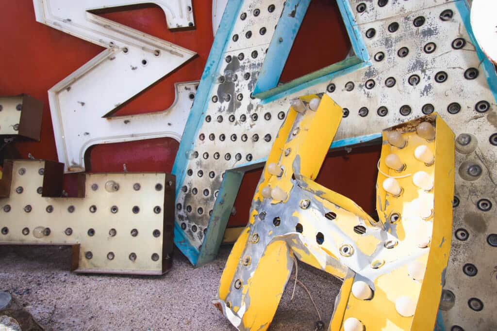 Red, yellow, blue, and white vintage neon letters. Visiting the Neon Boneyard is a must when you're in Las Vegas. Discover the rich history behind these Sin City icons, and what you need to know before you go! And for more travel tips and wanderlust inspiration, follow The Scenic Suitcase on Pinterest!