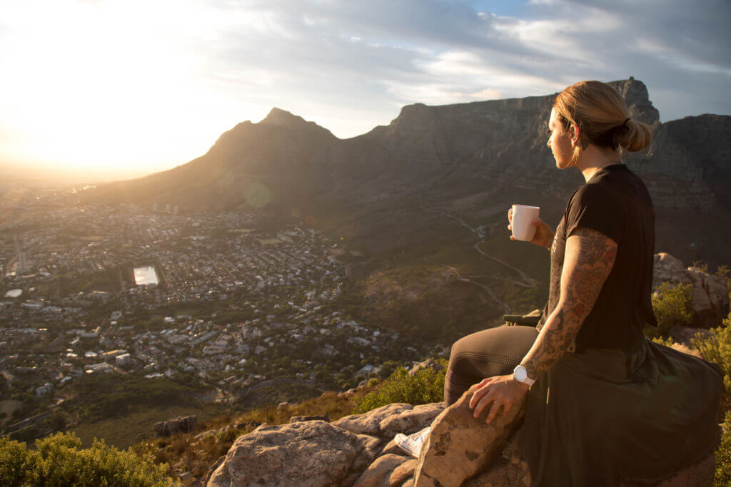 Girl drinking coffee on the top of Lionshead in Cape Town. Find out why attending The Blonde Abroad photography tour is a once-in-a-lifetime experience you shouldn't miss. And for more travel tips and wanderlust inspiration, follow The Scenic Suitcase on Pinterest!