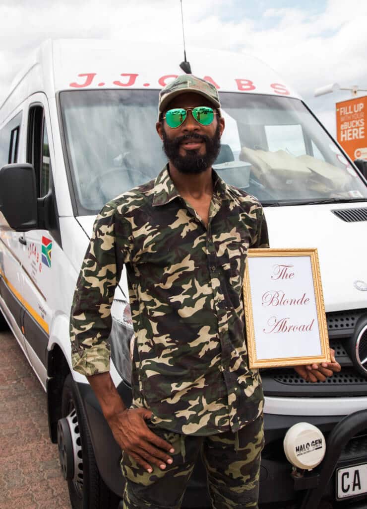 The driver Maueen holding a sign. Find out why attending The Blonde Abroad photography tour is a once-in-a-lifetime experience you shouldn't miss. And for more travel tips and wanderlust inspiration, follow The Scenic Suitcase on Pinterest!