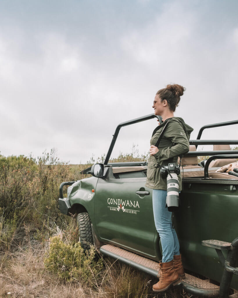 Girl standing on a safari vehicle.