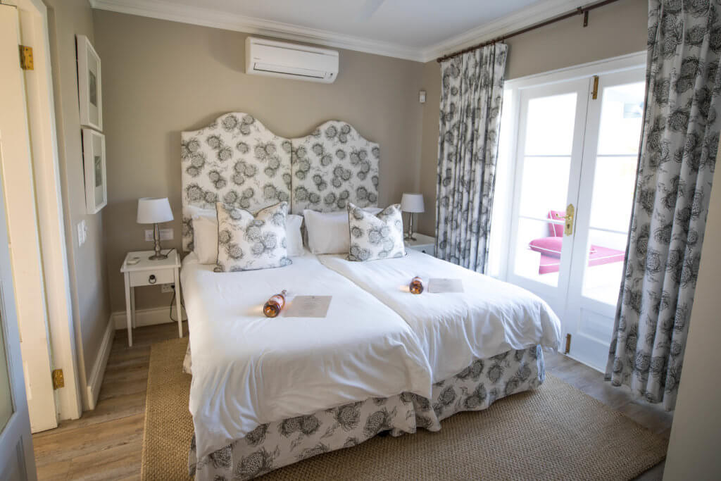 The quaint country bedroom at one of Boschendal's cottages. Visiting the Boschendal Wine Farm in South Africa is a treat for the senses. From delectable food to beautiful scenery to the savory wine, it's an experience that shouldn't be missed in South Africa. Here's what you need to know before you go. And for more travel tips and wanderlust inspiration, follow The Scenic Suitcase on Pinterest!