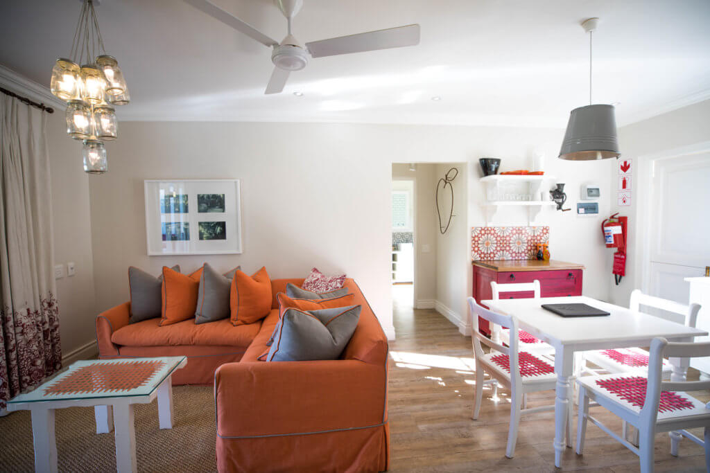 The orange and red accents of a cottage interior. Visiting the Boschendal Wine Farm in South Africa is a treat for the senses. From delectable food to beautiful scenery to the savory wine, it's an experience that shouldn't be missed in South Africa. Here's what you need to know before you go. And for more travel tips and wanderlust inspiration, follow The Scenic Suitcase on Pinterest!