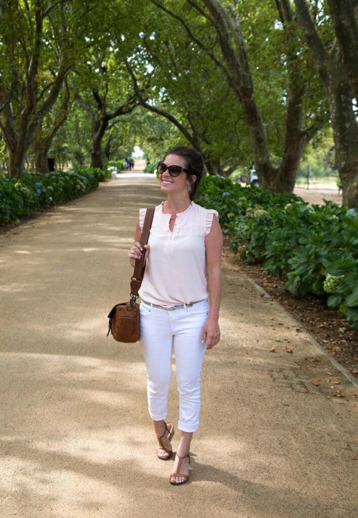 Girl walking down tree lined road. Visiting the Boschendal Wine Farm in South Africa is a treat for the senses. From delectable food to beautiful scenery to the savory wine, it's an experience that shouldn't be missed in South Africa. Here's what you need to know before you go. And for more travel tips and wanderlust inspiration, follow The Scenic Suitcase on Pinterest!
