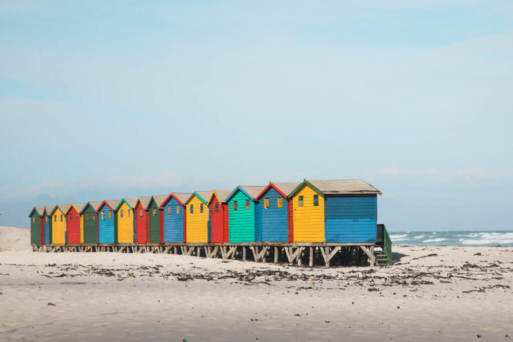 Colorful cottages along the beach. There are a million reasons to visit South Africa. The country is as diverse as it is beautiful and offers countless activities and bucket list adventures. Find out what you can't miss! And for more travel tips and wanderlust inspiration follow The Scenic Suitcase on Pinterest!
