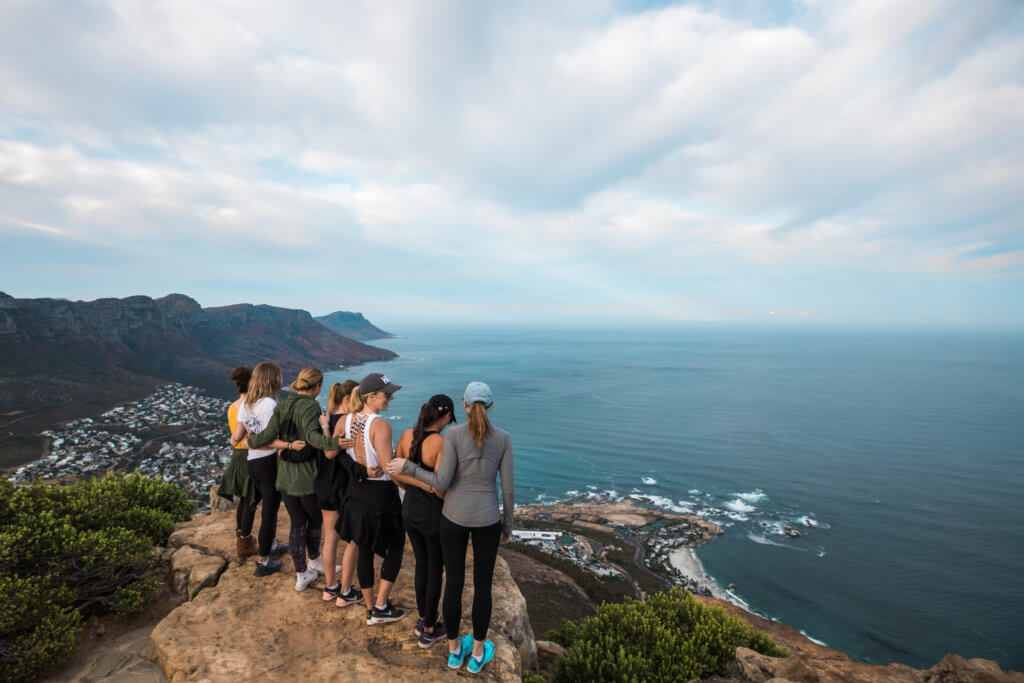 Girls standing together on the top of Lionshead looking out over the ocean. There are a million reasons to visit South Africa. The country is as diverse as it is beautiful and offers countless activities and bucket list adventures. Find out what you can't miss! And for more travel tips and wanderlust inspiration follow The Scenic Suitcase on Pinterest!