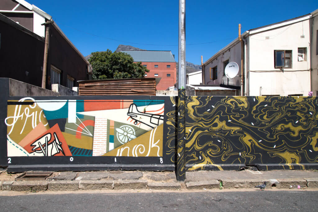 Graffiti along a street wall. Discover the unique street art of Woodstock in South Africa. Find out the history behind this eclectic district and why it's a must on any visit to Cape Town! And for more travel tips and wanderlust inspiration follow The Scenic Suitcase on Pinterest!
