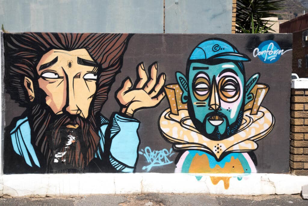 A man and a robot graffiti. Discover the unique street art of Woodstock in South Africa. Find out the history behind this eclectic district and why it's a must on any visit to Cape Town! And for more travel tips and wanderlust inspiration follow The Scenic Suitcase on Pinterest!