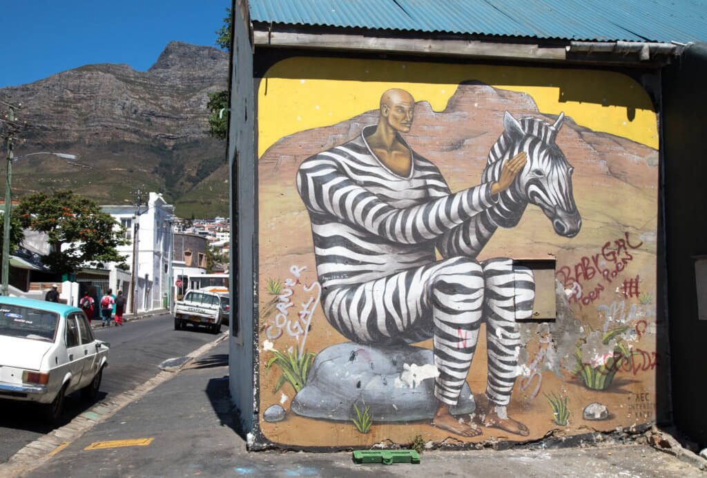 A man in a zebra suit graffiti. Discover the unique street art of Woodstock in South Africa. Find out the history behind this eclectic district and why it's a must on any visit to Cape Town! And for more travel tips and wanderlust inspiration follow The Scenic Suitcase on Pinterest!