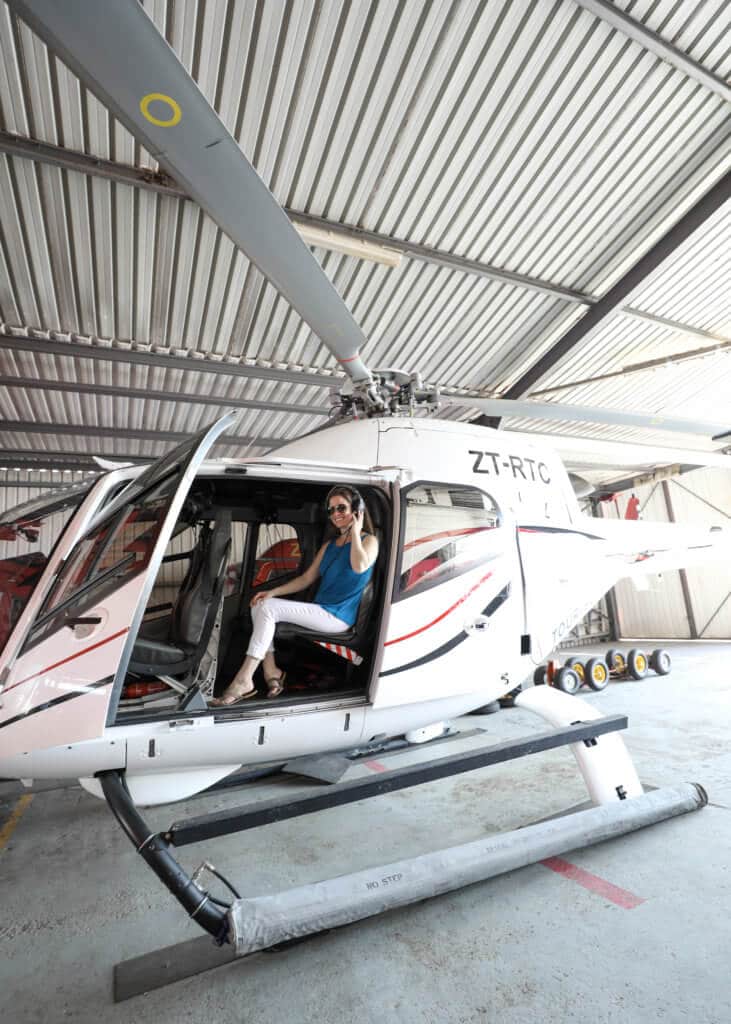 Girl sitting in the doorway of a helicopter. There are a million reasons to visit South Africa. The country is as diverse as it is beautiful and offers countless activities and bucket list adventures. Find out what you can't miss! And for more travel tips and wanderlust inspiration follow The Scenic Suitcase on Pinterest!