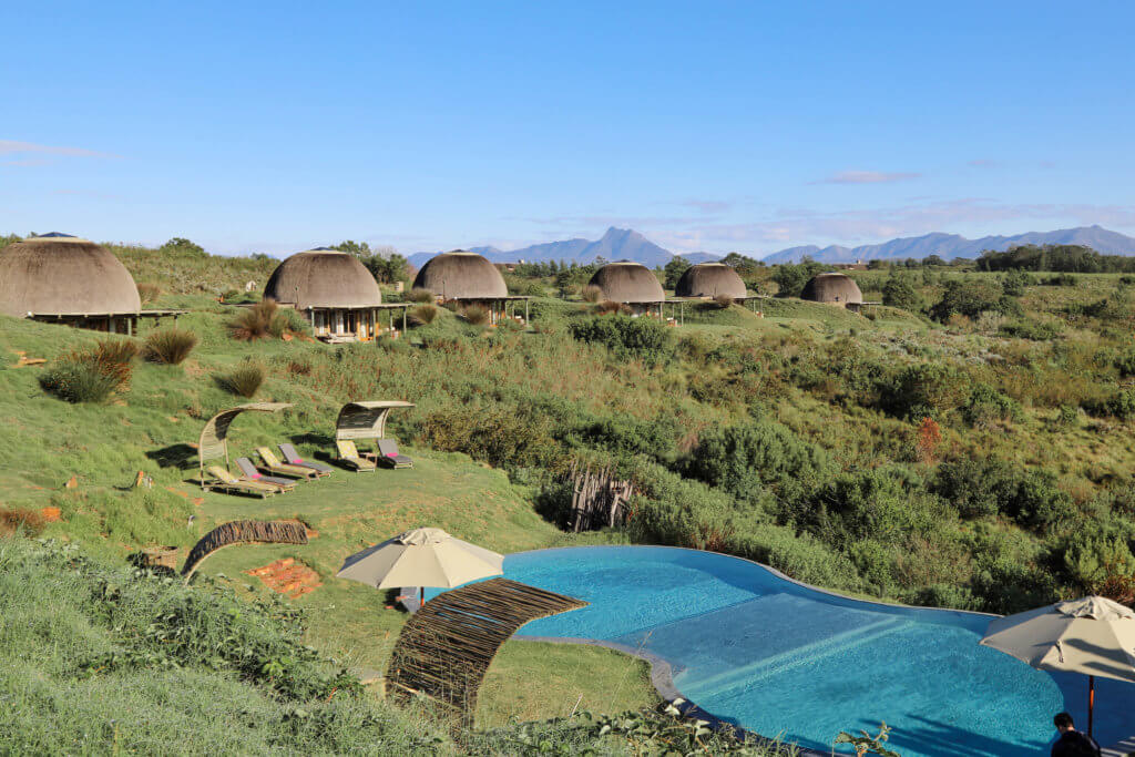 Huts near a swimming pool. An African safari at the Gondwana Game Reserve should be at the top of your bucket list! From luxuriously appointed rooms to stunning wildlife, it's an experience everyone should have when visiting South Africa. And for more travel tips and wanderlust inspiration, follow The Scenic Suitcase on Pinterest!