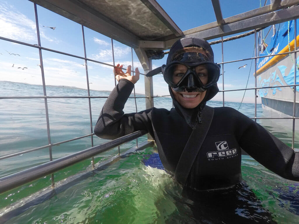 Girl inside a shark diving cage. Find out what it's like to go cage diving with great white sharks in South Africa! What to expect, what not to fear, and what company is the best to book your adventure with. And for more travel tips and wanderlust inspiration follow The Scenic Suitcase on Pinterest!