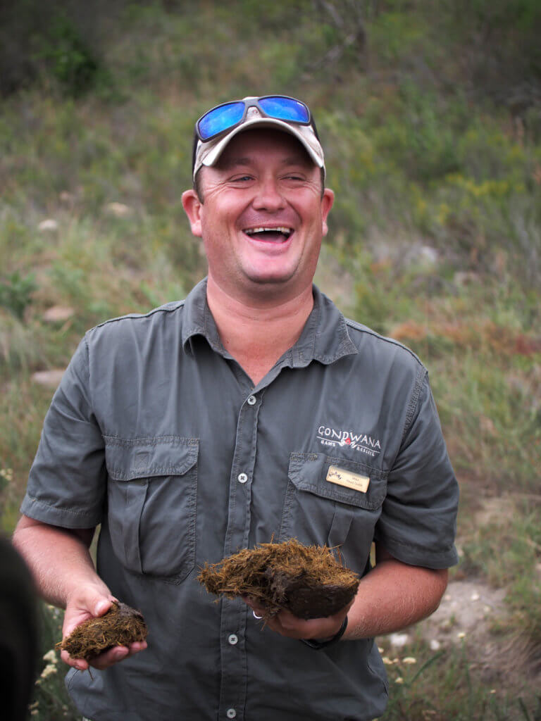 A park ranger laughing as he holds elephant dung. An African safari at the Gondwana Game Reserve should be at the top of your bucket list! From luxuriously appointed rooms to stunning wildlife, it's an experience everyone should have when visiting South Africa. And for more travel tips and wanderlust inspiration, follow The Scenic Suitcase on Pinterest!