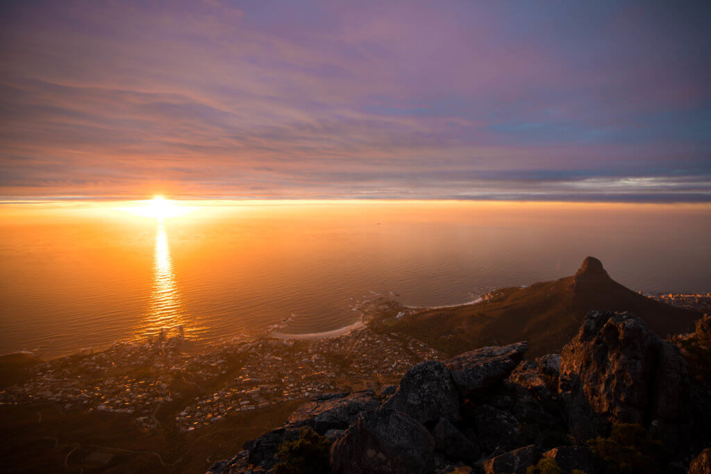 Sunset over the ocean from the top of Table Mountain. There are a million reasons to visit South Africa. The country is as diverse as it is beautiful and offers countless activities and bucket list adventures. Find out what you can't miss! And for more travel tips and wanderlust inspiration follow The Scenic Suitcase on Pinterest!