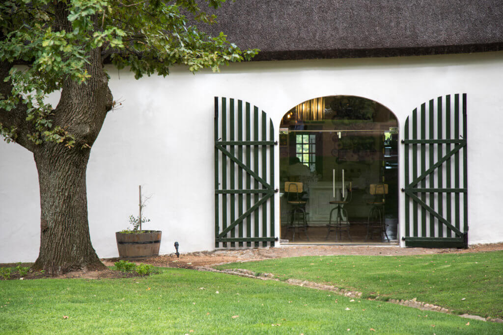 A farm house door with a tree. There are a million reasons to visit South Africa. The country is as diverse as it is beautiful and offers countless activities and bucket list adventures. Find out what you can't miss! And for more travel tips and wanderlust inspiration follow The Scenic Suitcase on Pinterest!
