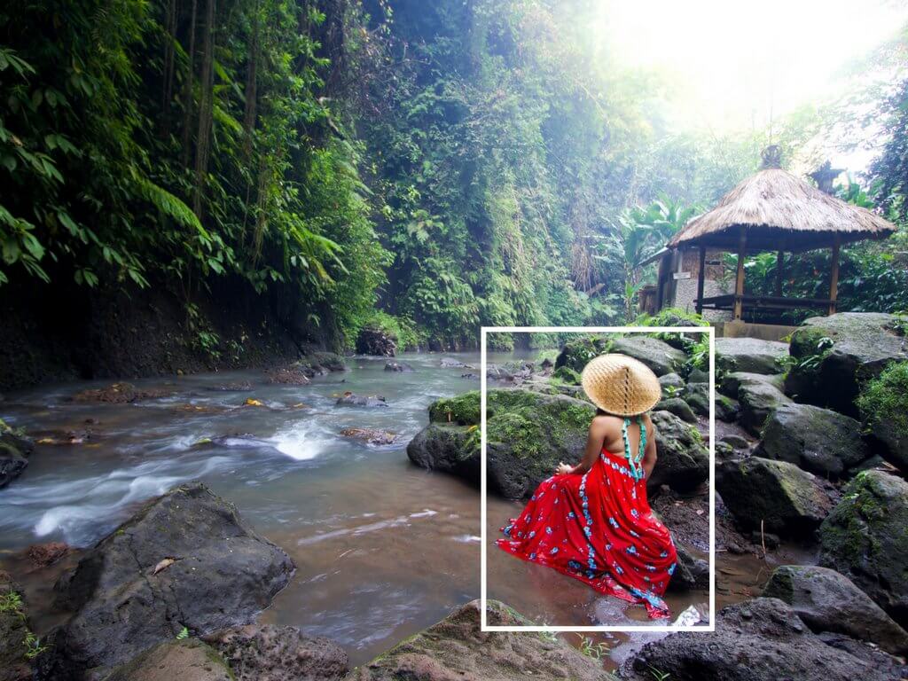 A girl sitting in a lush riverbed wearing a bright red dress. Using these travel photography composition tips, your images will look just as astounding as the places you visit! Discover all you need to know for jaw-dropping photos! And for more travel tips and wanderlust inspiration follow The Scenic Suitcase on Pinterest!