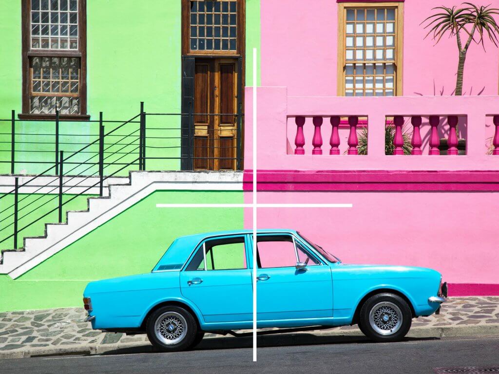 A blue car in front of a green and pink building. Using these travel photography composition tips, your images will look just as astounding as the places you visit! Discover all you need to know for jaw-dropping photos! And for more travel tips and wanderlust inspiration follow The Scenic Suitcase on Pinterest!