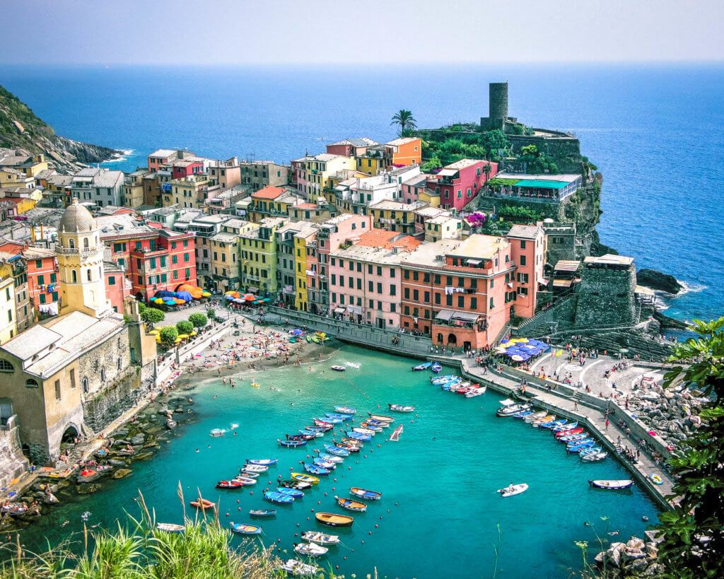Colorful buildings along a bay and the ocean in Italy. Discover 20 of the most iconic photo locations in the world, with links to a map of where you can find them! And for more wanderlust inspiration and travel tips, follow The Scenic Suitcase on Pinterest!