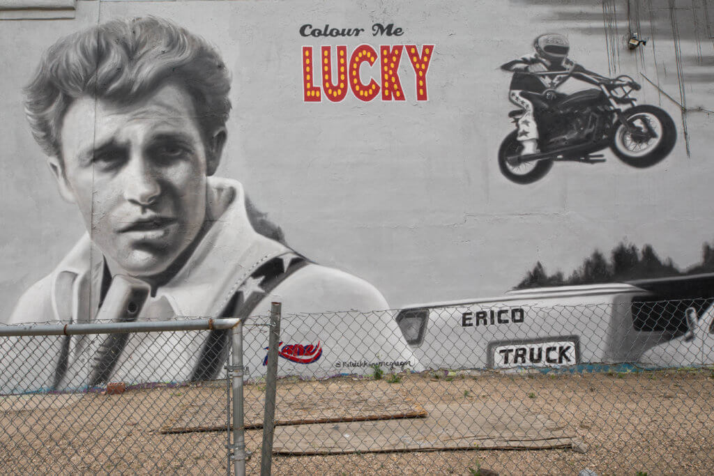 Graffiti art of a man and a motorcycle in black and white that says "Colour Me Lucky". Discover where to find the best street art in Denver! From memorable murals to colorful characters, here's what you need to know. And for more travel tips and wanderlust inspiration, follow The Scenic Suitcase on Pinterest!