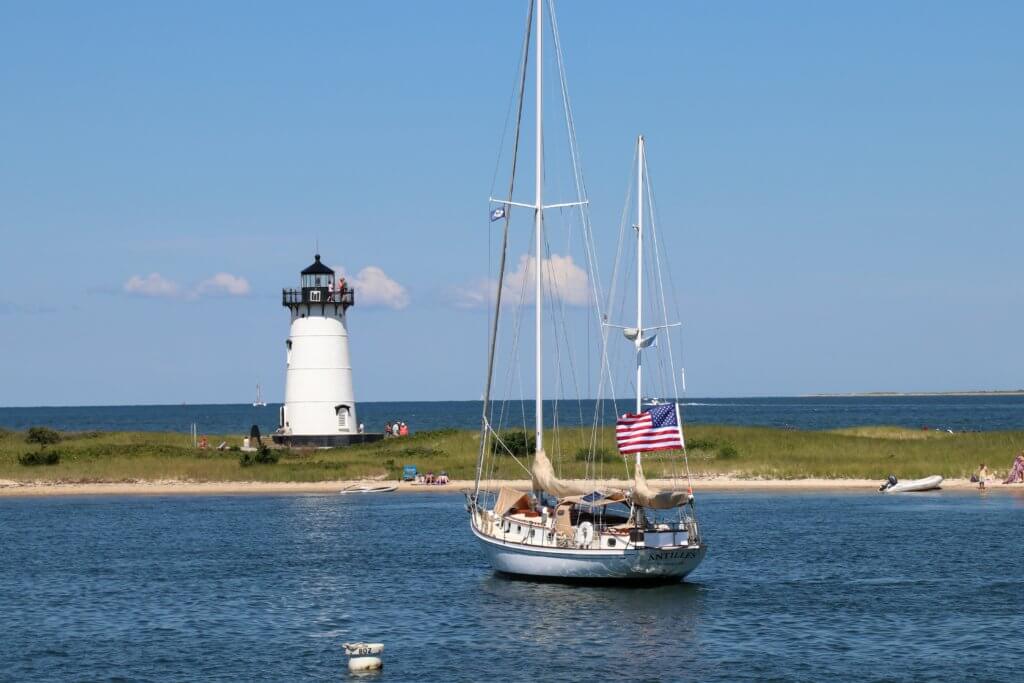 A sailboat with an American flag near a white lighthouse in Martha's Vineyard. Whether it's the Statue of Liberty, Washington DC, or a quaint hometown parade, these americana images capture the essence of the good ol' U.S.A. And for more travel tips and wanderlust inspiration, follow The Scenic Suitcase on Pinterest!