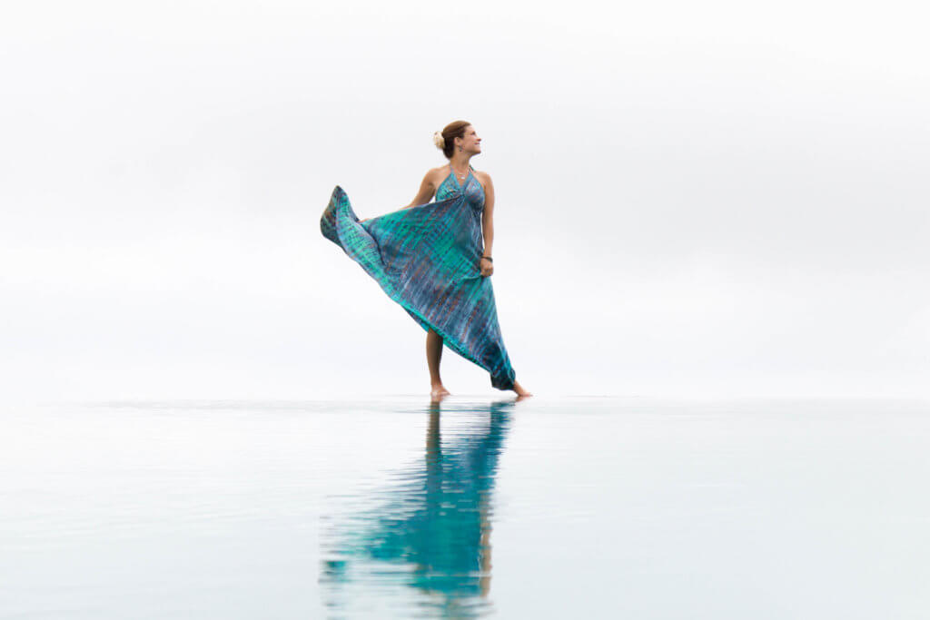 A girl with a flowing dress on the edge of a reflective infinity pool. Trying to figure out how to use a DSLR camera can feel as impossible as trying to figure out how to launch the space shuttle. But it doesn't have to be complicated! Learn the basics of how to stop shooting in auto and start shooting in awesome! And for more travel and photography tips, follow The Scenic Suitcase on Pinterest!