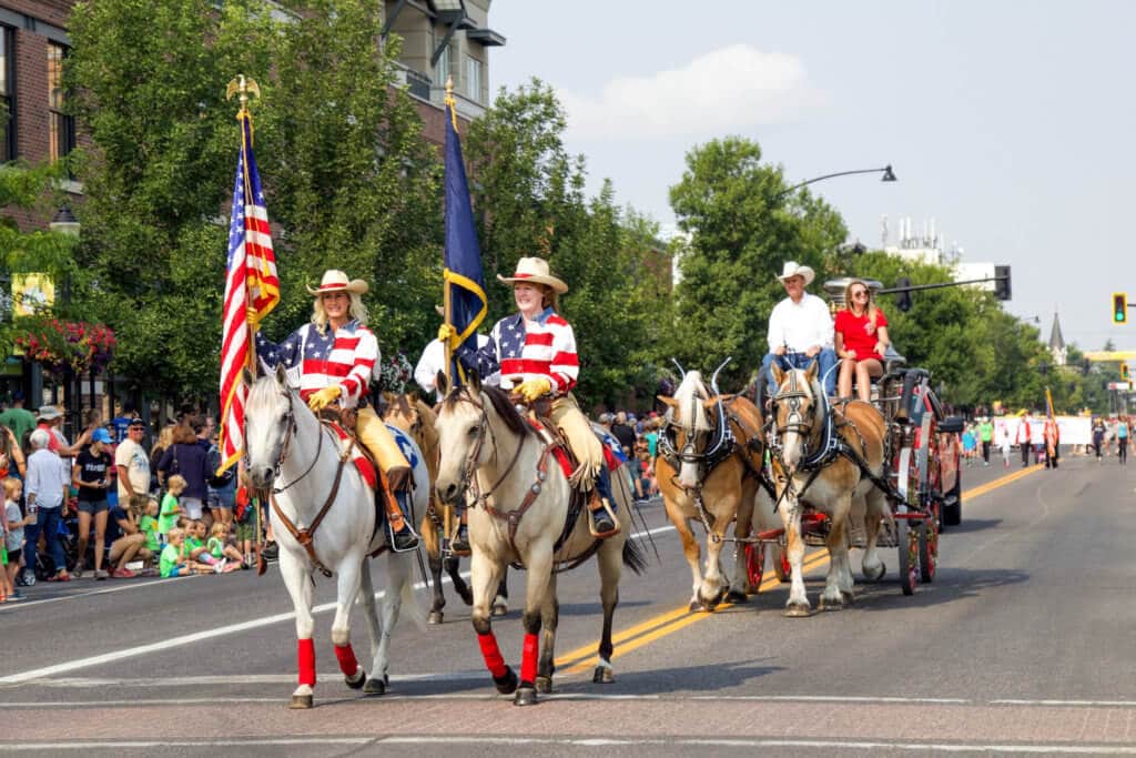 Women carrying flags on horses with a horsedrawn carriage trailing behind during a hometown parade. Whether it's the Statue of Liberty, Washington DC, or a quaint hometown parade, these americana images capture the essence of the good ol' U.S.A. And for more travel tips and wanderlust inspiration, follow The Scenic Suitcase on Pinterest!