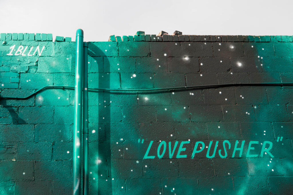 Graffiti art on the bricks of a building. Discover where to find the best street art in Denver! From memorable murals to colorful characters, here's what you need to know. And for more travel tips and wanderlust inspiration, follow The Scenic Suitcase on Pinterest!