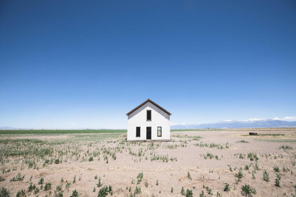 An abandon white house in the middle of nowhere with mountains far off in the distance. Get the inside scoop about visiting the Great Sand Dunes from a Colorado local. From where to find them to tips when you get there, this guide has it all! And for more travel tips and wanderlust inspiration, follow The Scenic Suitcase on Pinterest!