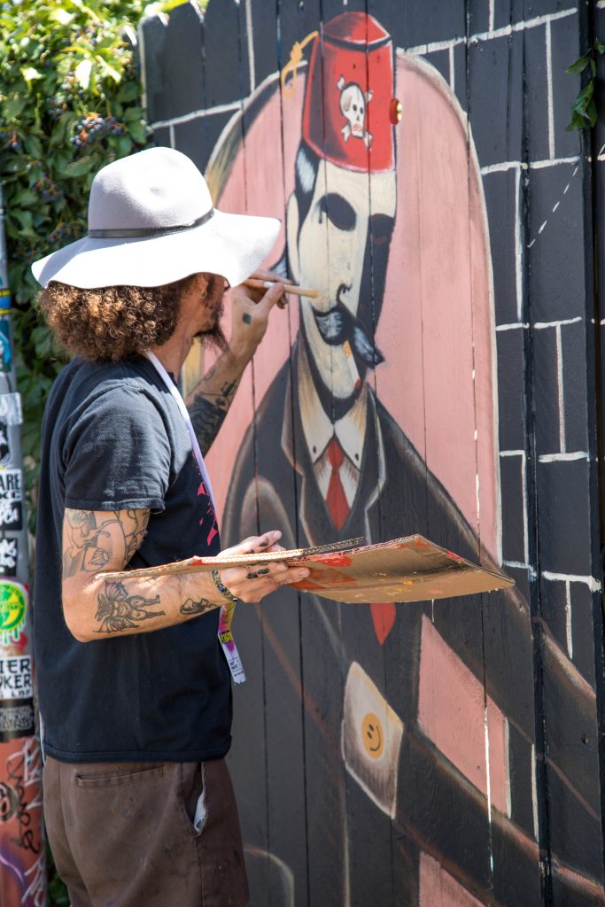 A street artist painting a mural in Denver.