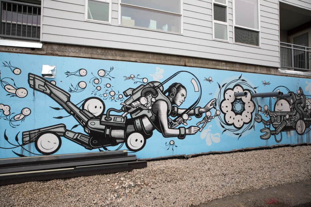 Graffiti art of a female scuba diver with swimming smiley faces around her. Discover where to find the best street art in Denver! From memorable murals to colorful characters, here's what you need to know. And for more travel tips and wanderlust inspiration, follow The Scenic Suitcase on Pinterest!