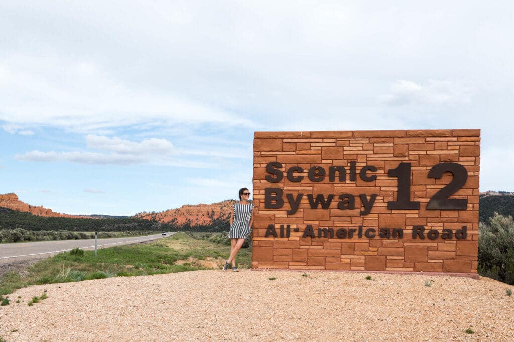 A girl in a striped jumper standing next to the Scenic Byway 12 road sign. Discover some of the most beautiful places in the American Southwest. Awe-inspiring destinations and what you shouldn't miss on your next road trip! And for more travel tips and wanderlust inspiration, follow The Scenic Suitcase on Pinterest!