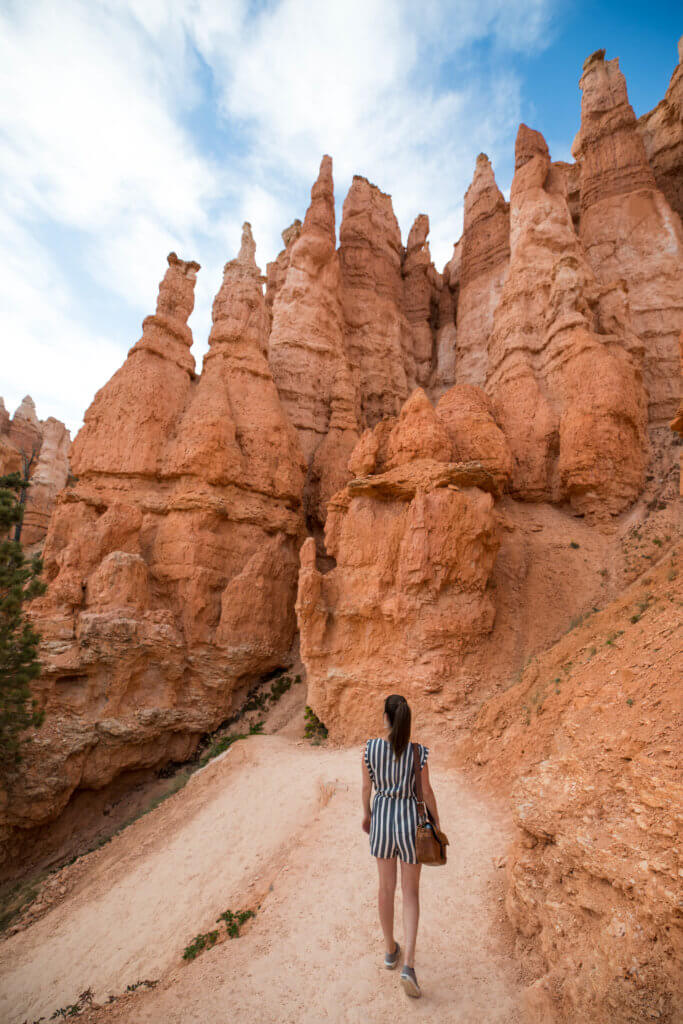 A girl hiking along a trail in Bryce National Park in a striped jumper. Discover some of the most beautiful places in the American Southwest. Awe-inspiring destinations and what you shouldn't miss on your next road trip! And for more travel tips and wanderlust inspiration, follow The Scenic Suitcase on Pinterest!