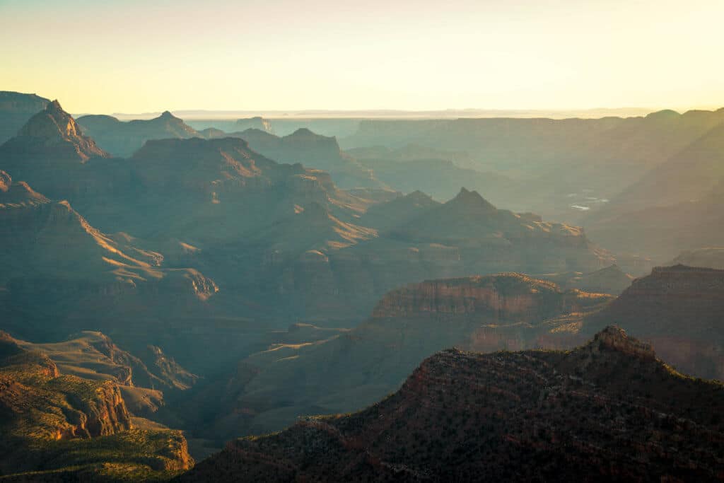 Soft colors of sunrise over the Grand Canyon. Discover some of the most beautiful places in the American Southwest. Awe-inspiring destinations and what you shouldn't miss on your next road trip! And for more travel tips and wanderlust inspiration, follow The Scenic Suitcase on Pinterest!